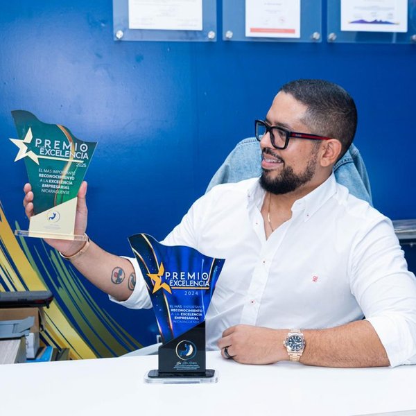 El Dr. Steve Henríquez en su consultorio con los premios a la Excelencia Empresarial 2024 y 2025